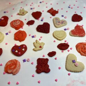 Cookies in different shapes, such as roses, bears, birds, hearts, and kisses