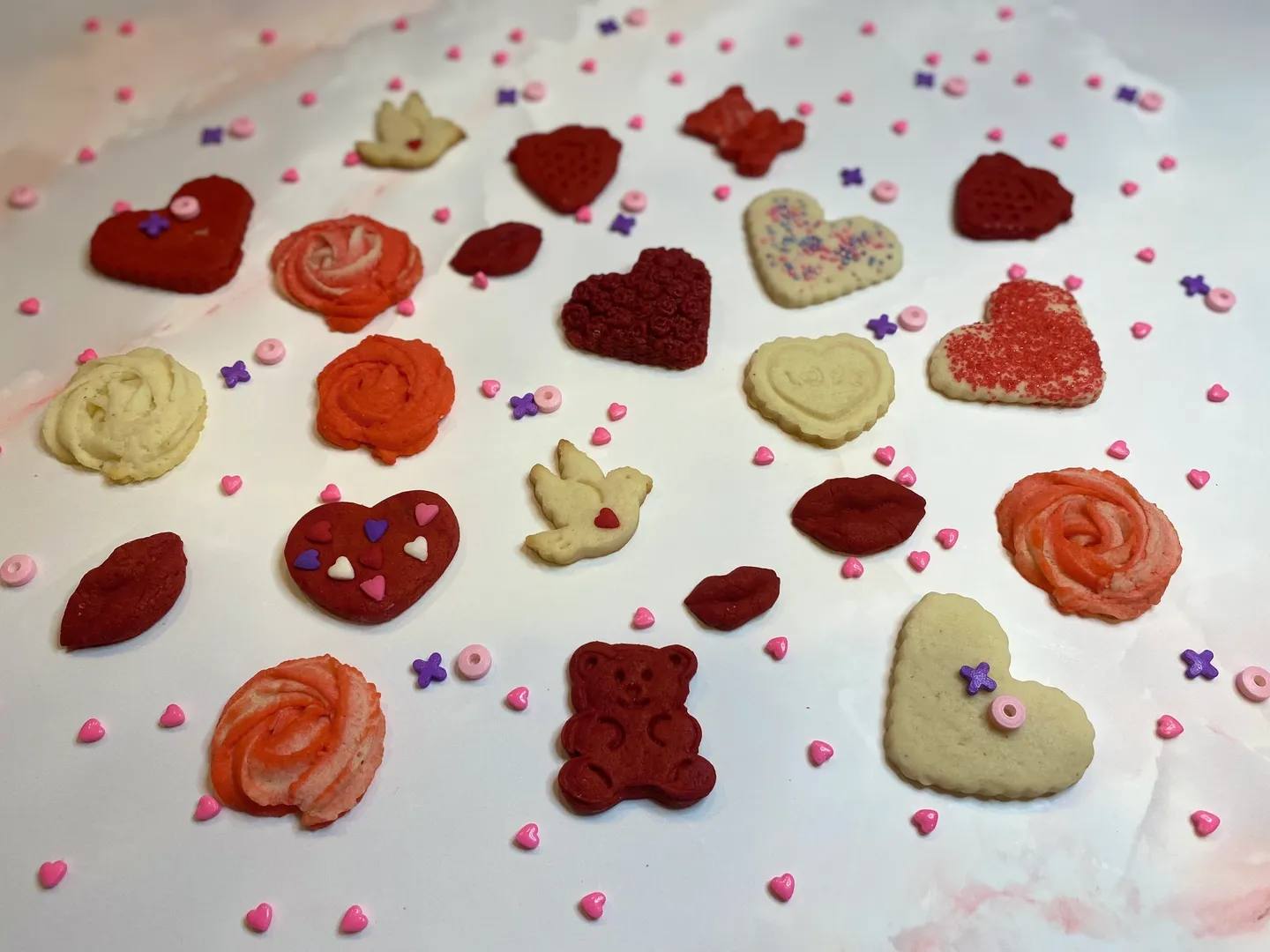 Cookies in different shapes, such as roses, bears, birds, hearts, and kisses